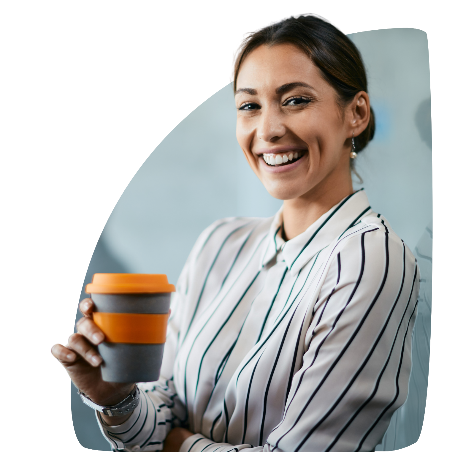 A woman in a striped shirt is holding a cup of coffee and smiling.