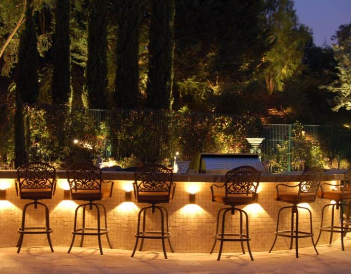 A row of bar stools are lit up at night