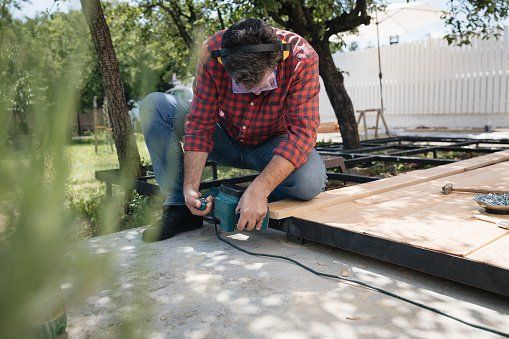 A man is using a circular saw to cut a piece of wood.