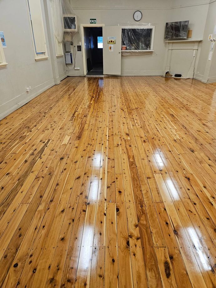 A large room with a wooden floor and a door.