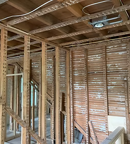 Interior of a home under renovation, showing exposed wooden framing and unfinished walls.