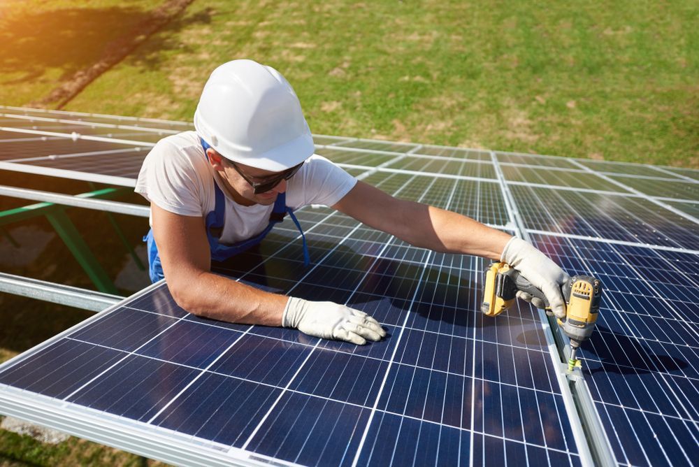 Solar Panel Installer In White Hard Hat Using A Drill — GSA Group In Mackay, QLD