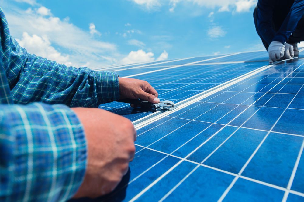 Workers Installing Solar Panels On A Rooftop Under A Partly Cloudy Sky — GSA Group In Garbutt, QLD