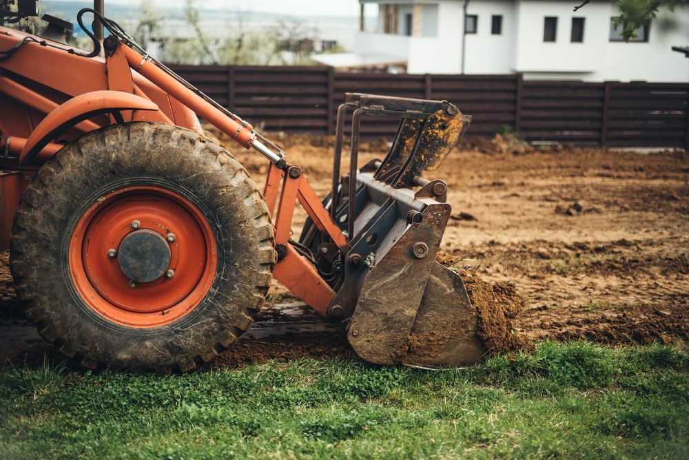 Large Orange Tractor With Scoop Digging Into Dirt — Mareeba Crane Hire In Cooktown, QLD
