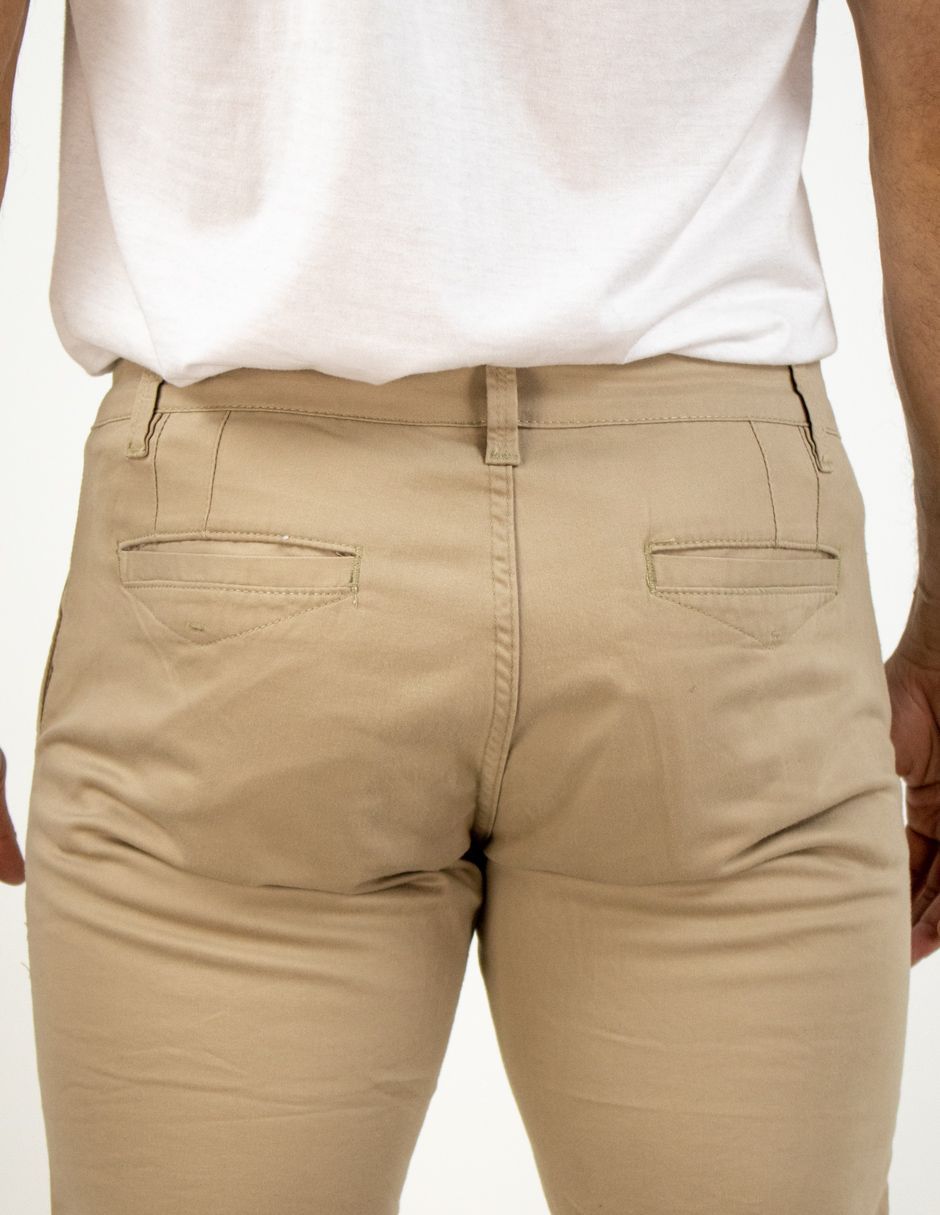 Vista trasera de unos pantalones beige combinados con una camisa blanca.