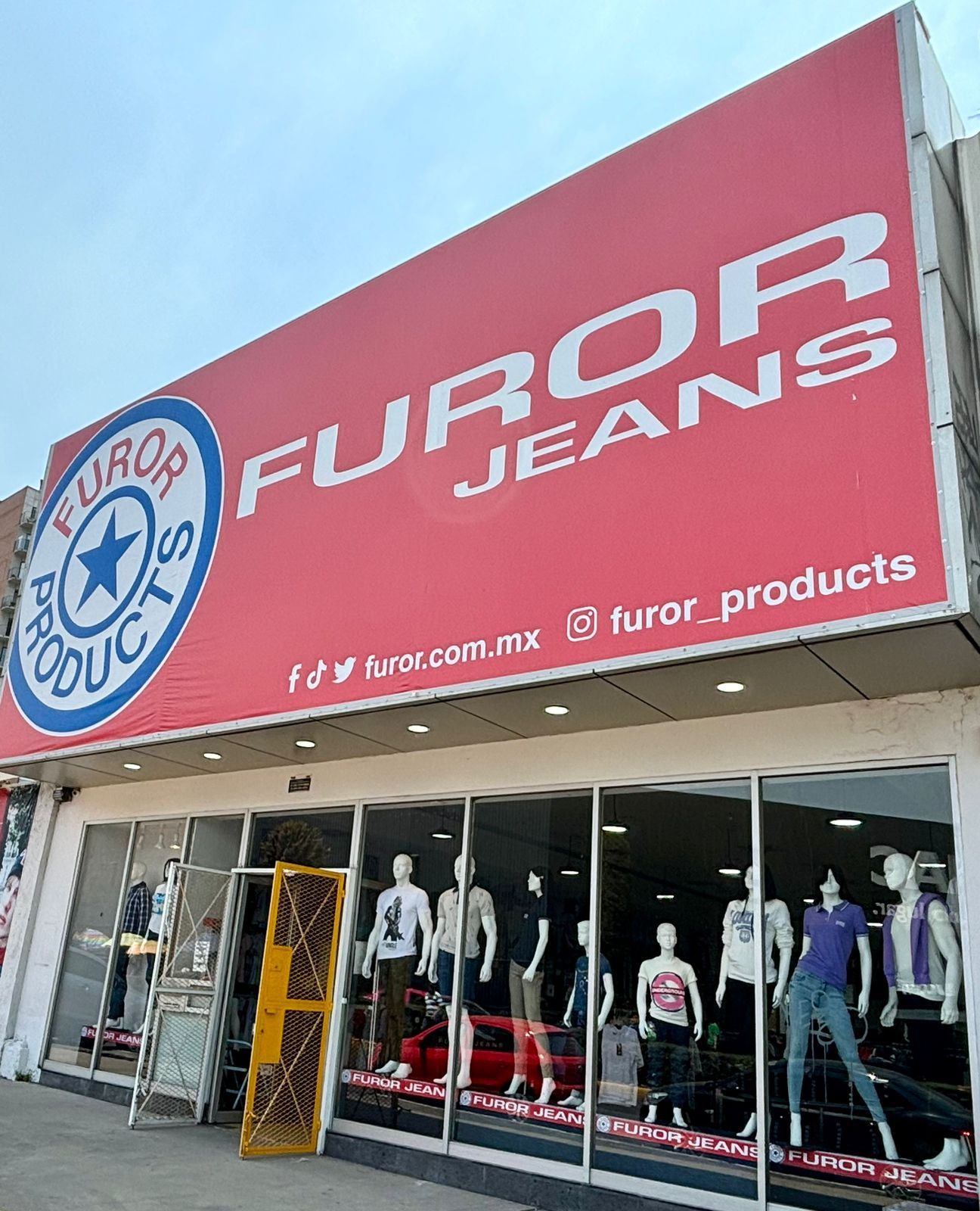 Un frente de tienda con muchos maniquíes frente a él. Furor Jeans