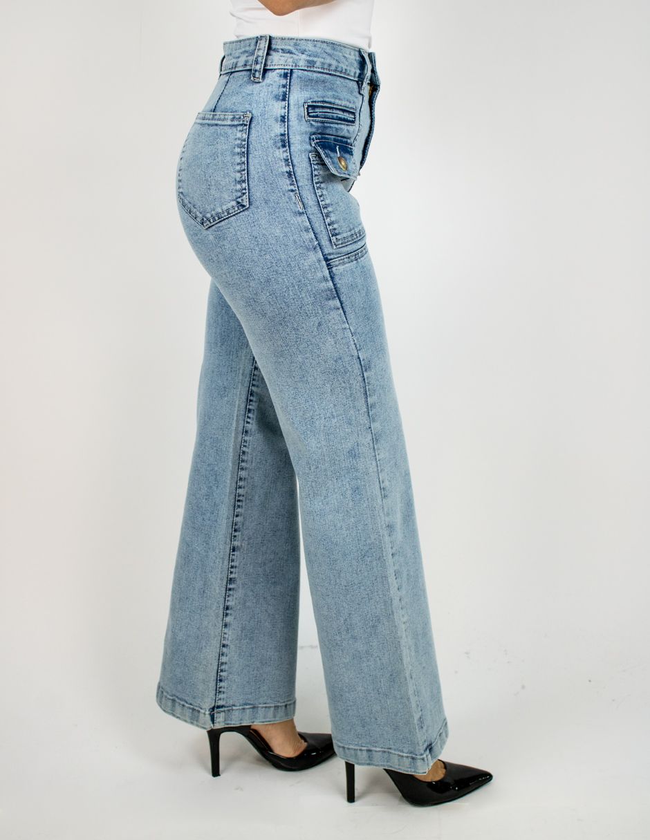 Pantalones vaqueros acampanados de color azul claro con tacones negros, mostrados de perfil sobre un fondo blanco.