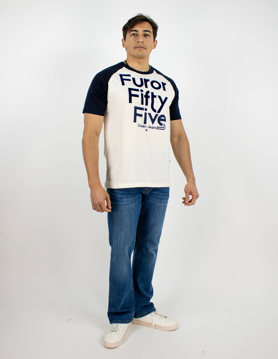 Hombre de pie sobre un fondo blanco, vistiendo una camiseta blanca con el texto azul marino 