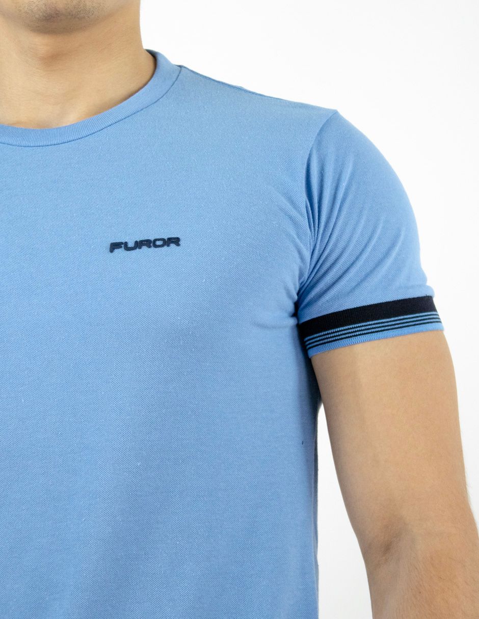 Primer plano de una persona con una camiseta azul claro con ribete de rayas en las mangas.