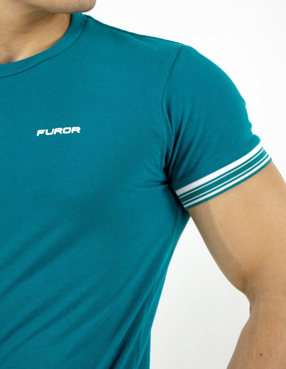 Camiseta de canalé color verde azulado con manga a rayas blancas en la parte superior del torso y el brazo de una persona.