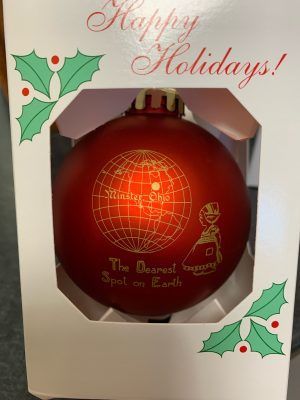 Red holiday ornament in a white gift box with “Happy Holidays!” and “The Dawn of a New Spot on Earth” text.