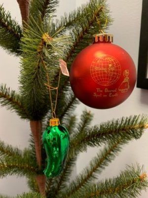 Green and red glass ornaments hanging on a Christmas tree branch