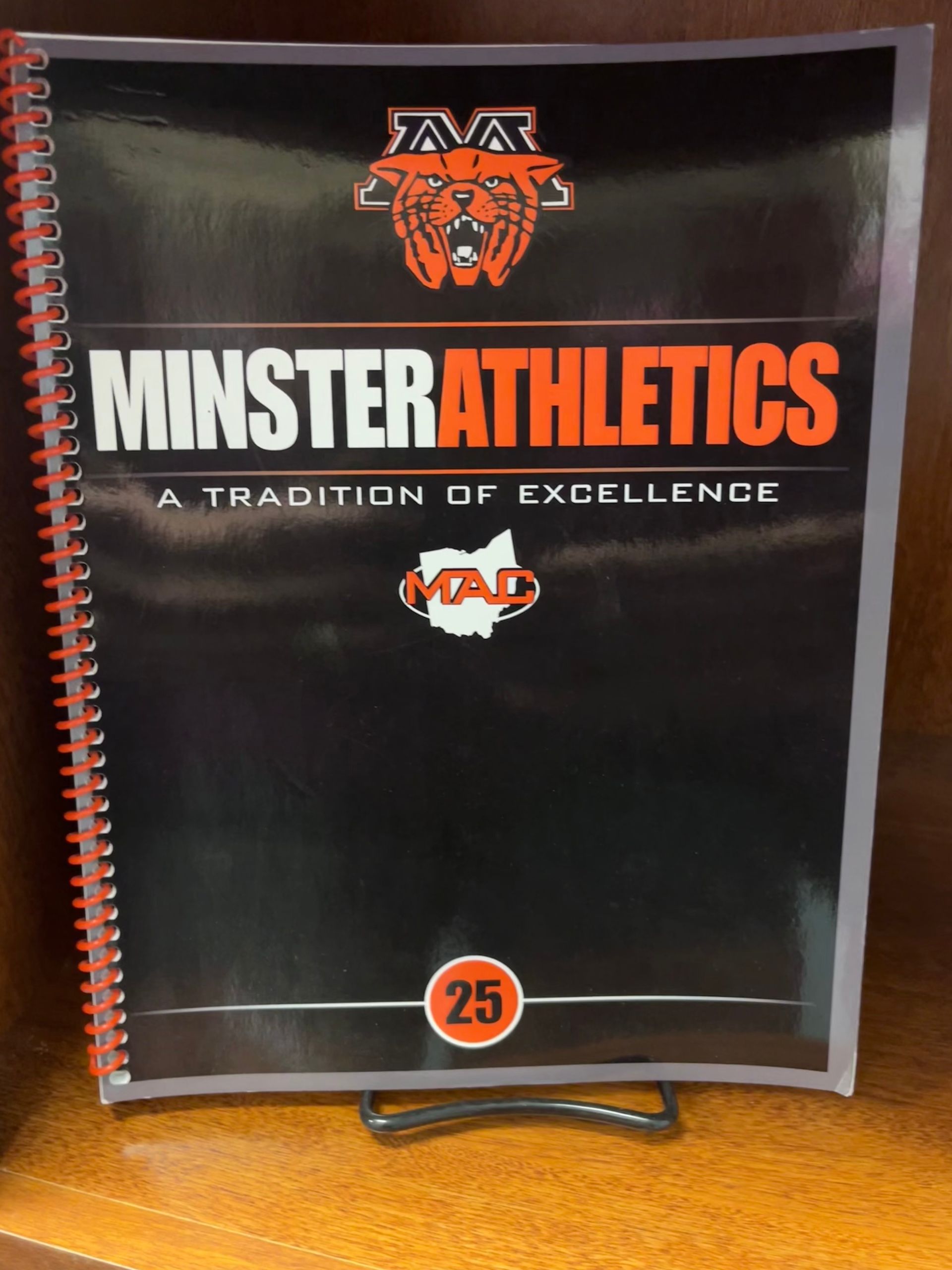 Minnesota athletics spiral-bound booklet with orange and black cover on a stand