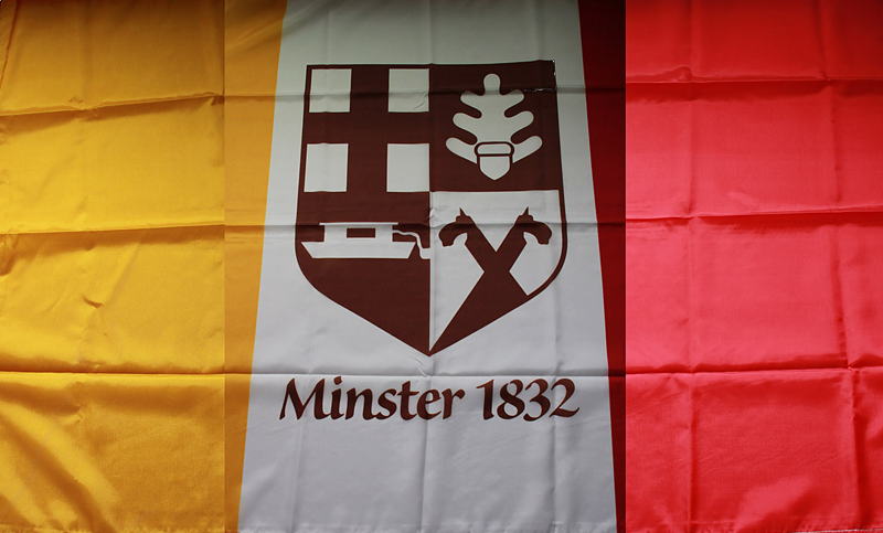 Maroon and gold Minster 1832 flag with a central crest and the text “Minster 1832”