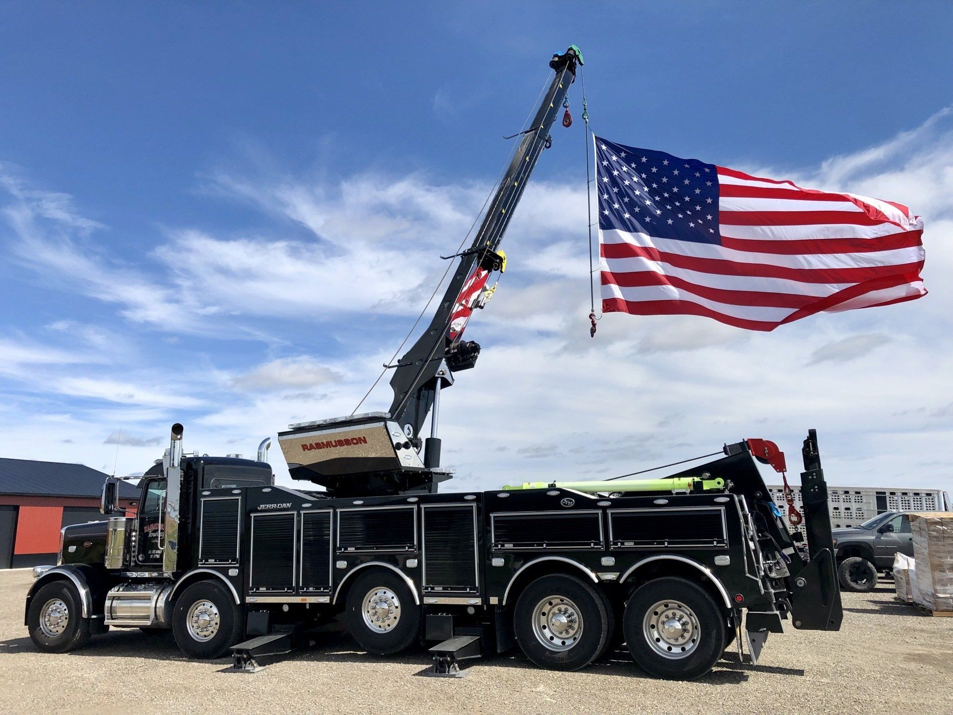 A tow truck with an American flag on top of it
