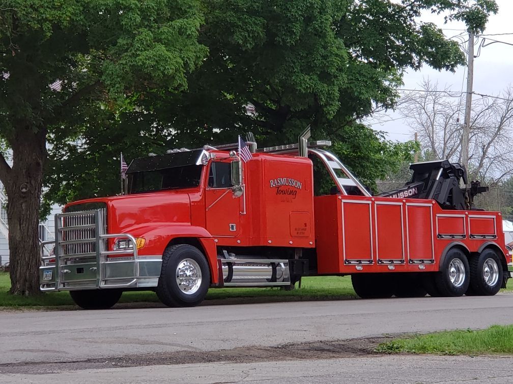 A red tow truck is parked on the side of the road