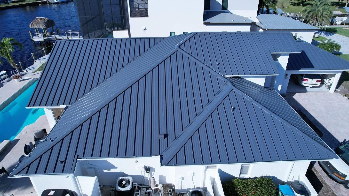 An aerial view of a house with a blue roof and a pool.