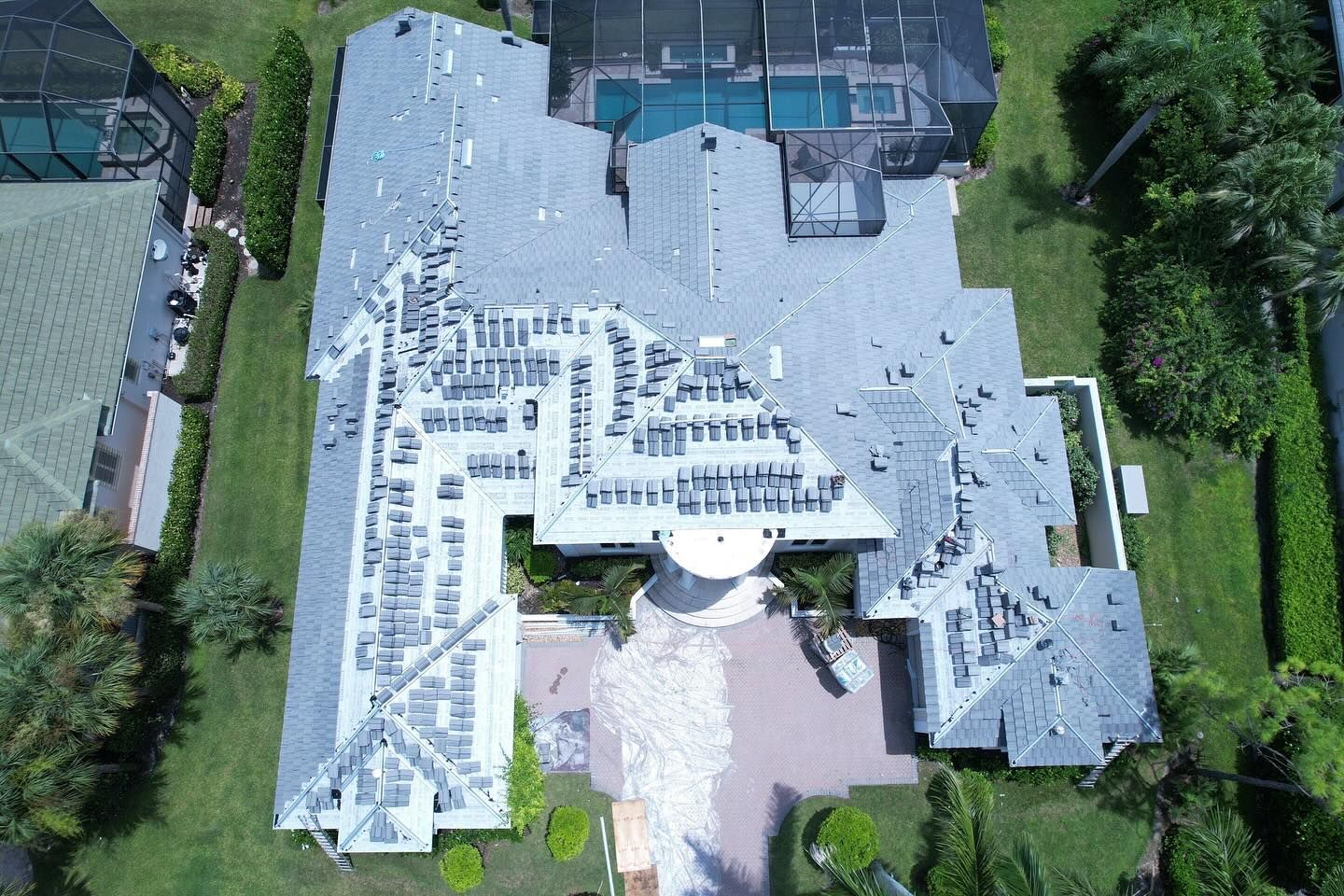 An aerial view of a large house with a pool in the backyard.