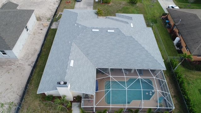 An aerial view of a house with a screened in pool