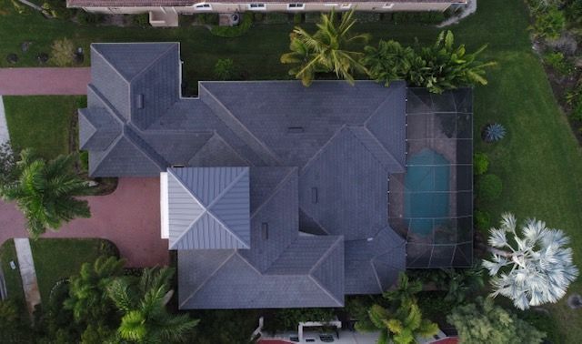 An aerial view of a large house with a pool in the backyard.