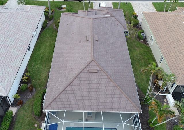 An aerial view of a house with a roof and a pool.
