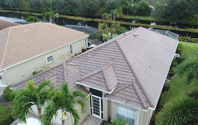 An aerial view of a house with a tile roof and palm trees.