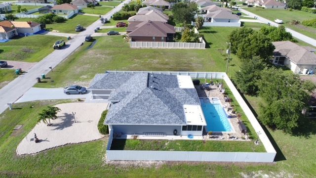 An aerial view of a house with a pool in the backyard