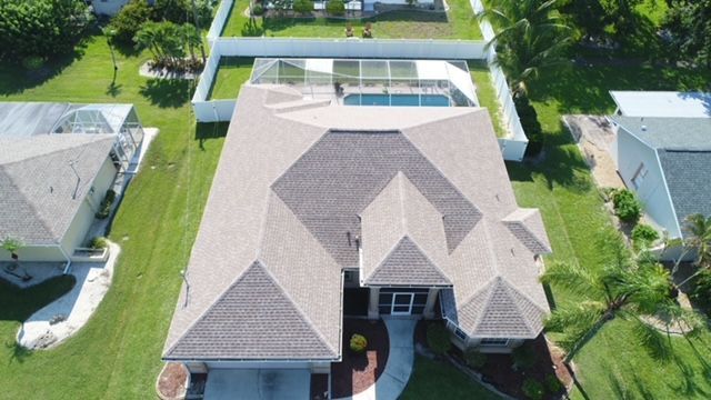 An aerial view of a house with a pool in the backyard.