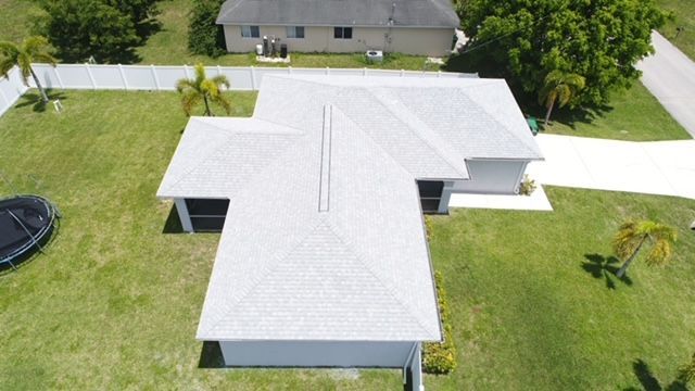 An aerial view of a house with a trampoline in the backyard