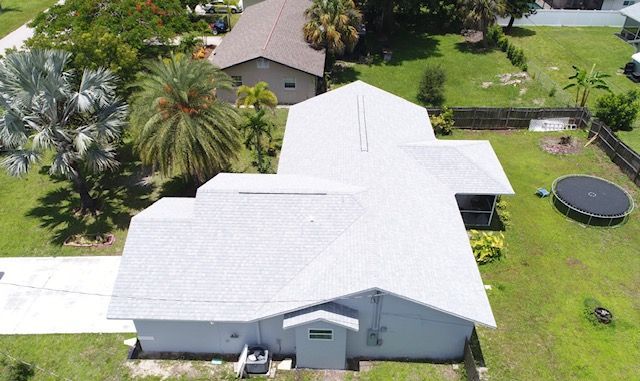 An aerial view of a house with a trampoline in the backyard.