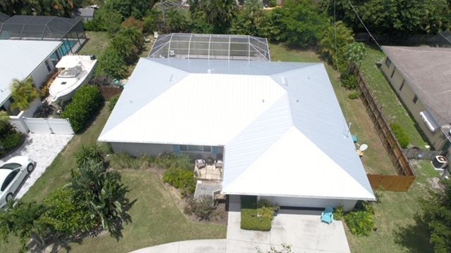An aerial view of a house with a white roof
