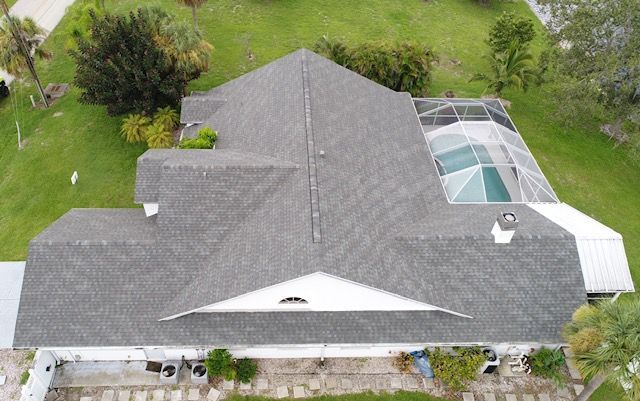 An aerial view of a house with a roof and a pool.