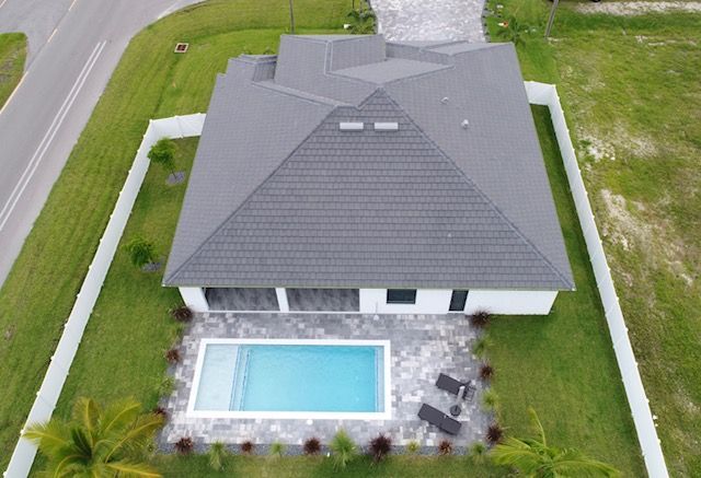 An aerial view of a house with a pool in the backyard.