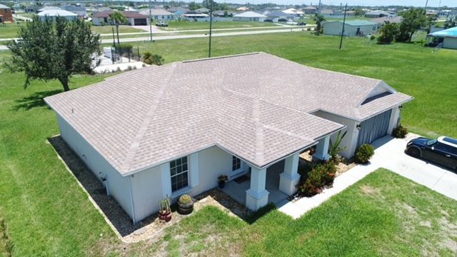 An aerial view of a house with a car parked in front of it.