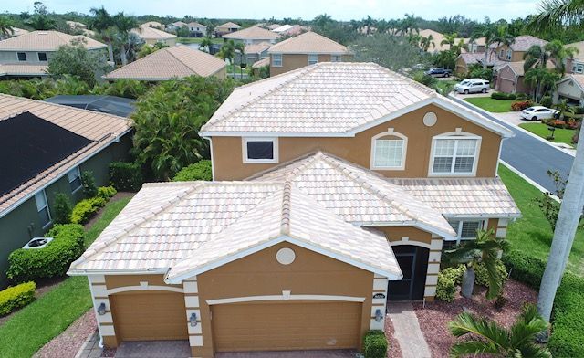 An aerial view of a large house with a tiled roof in a residential area.
