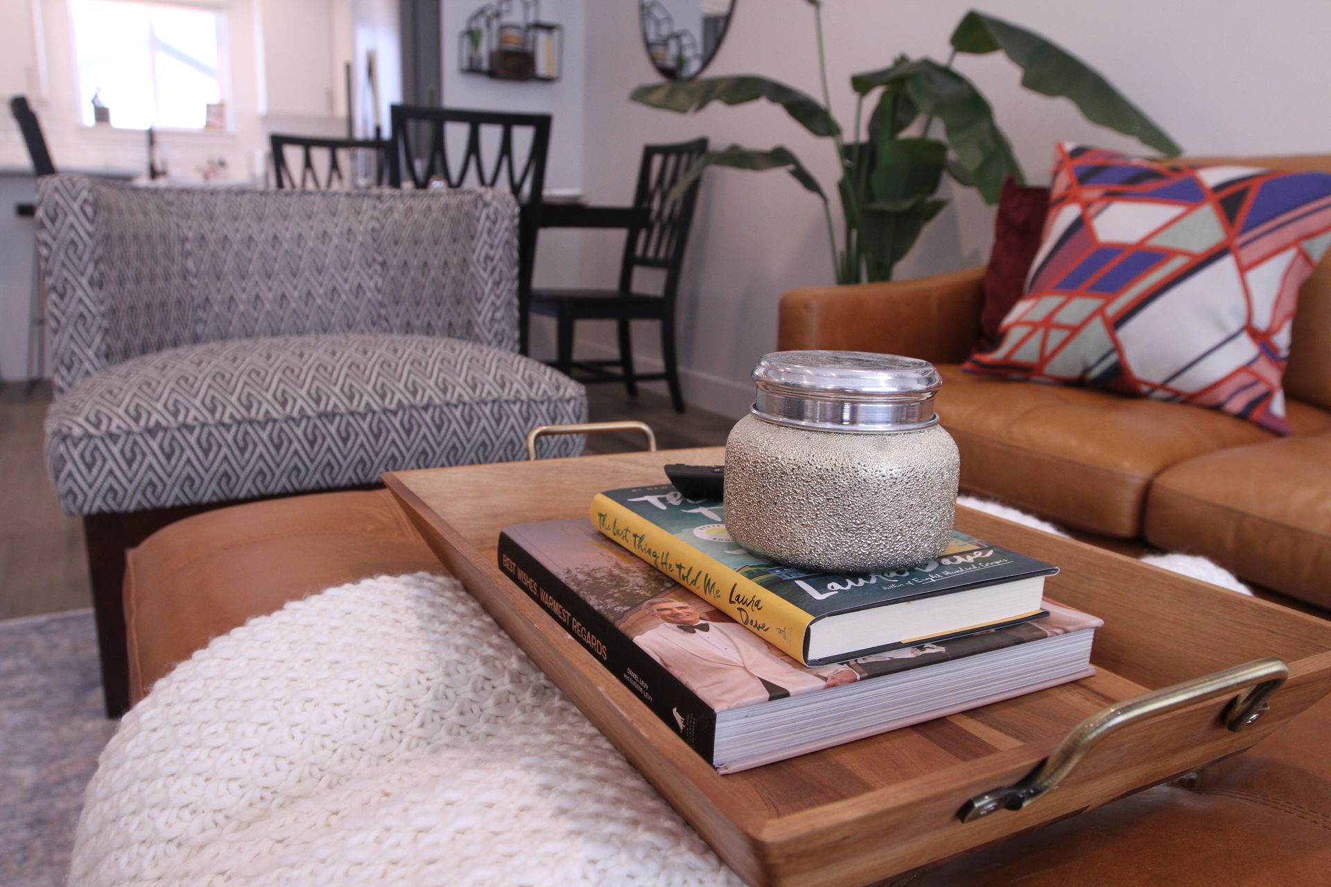 Cozy living room with leather sofa, patterned chair, and coffee table with books and a glass jar Madison Towns on 40th