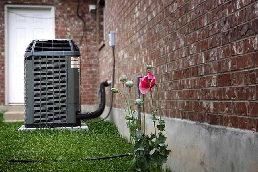 An industrial HVAC unit with two pleated filters sits inside a utility closet with light-colored walls and carpet.