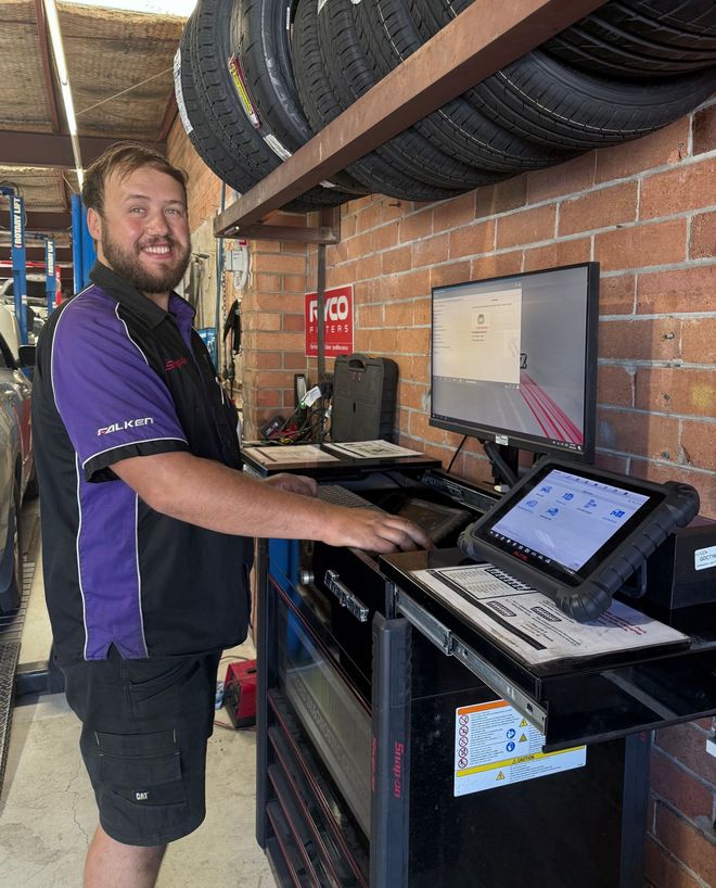 Ryan, a qualified mechanic in newcastle using a diagnostic tool in the workshop — AutoHop Lambton in Lambton, NSW
