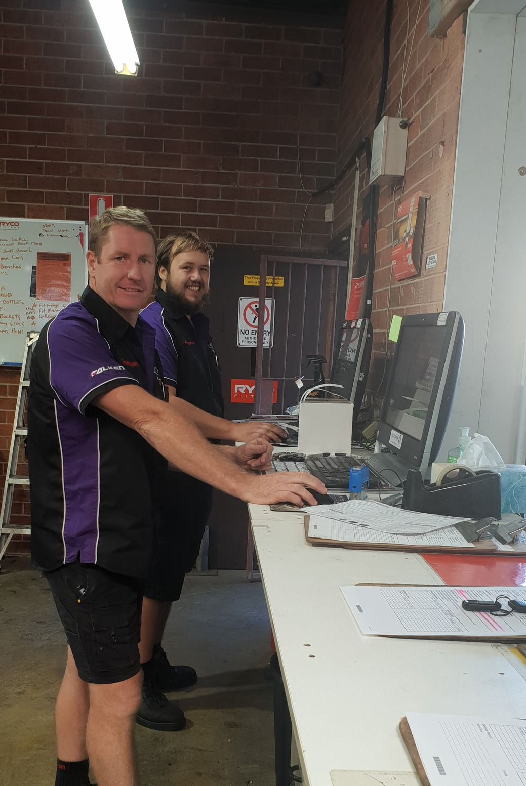 Two Men at A Counter, Typing on Computers in An Auto Repair Shop — AutoHop Lambton in Lambton, NSW