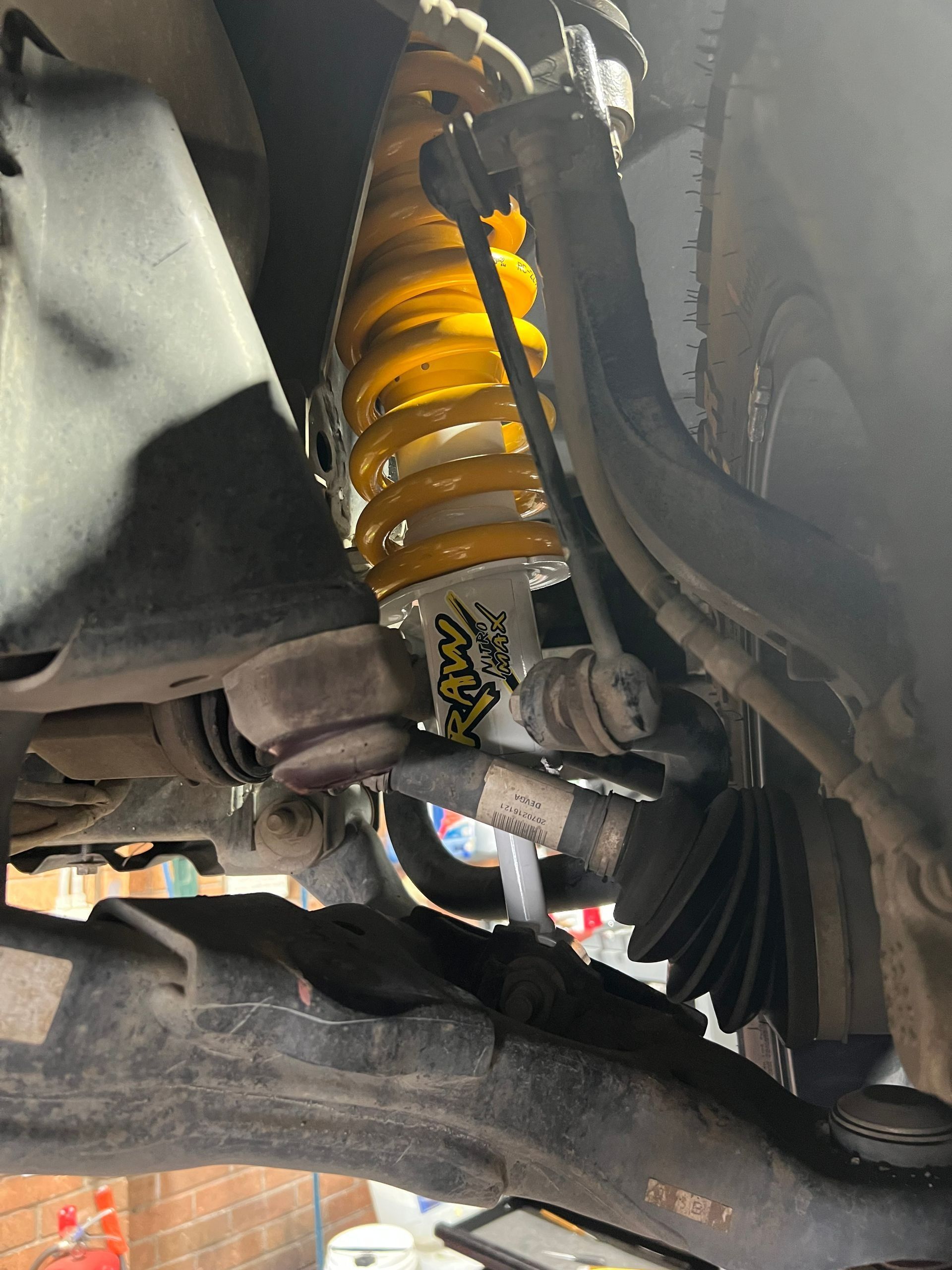 Yellow Shock Absorber in A Vehicle Suspension System fitted by a qualifed mechanic in Newcastle — AutoHop Lambton in Lambton, NSW