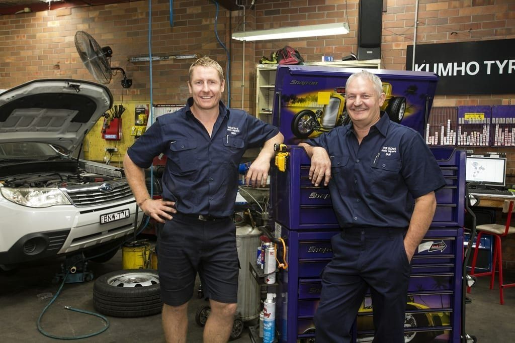 Two Mechanics in A Garage, Leaning on A Tool Chest Next to A Car with An Open Hood — AutoHop Lambton in Lambton, NSW