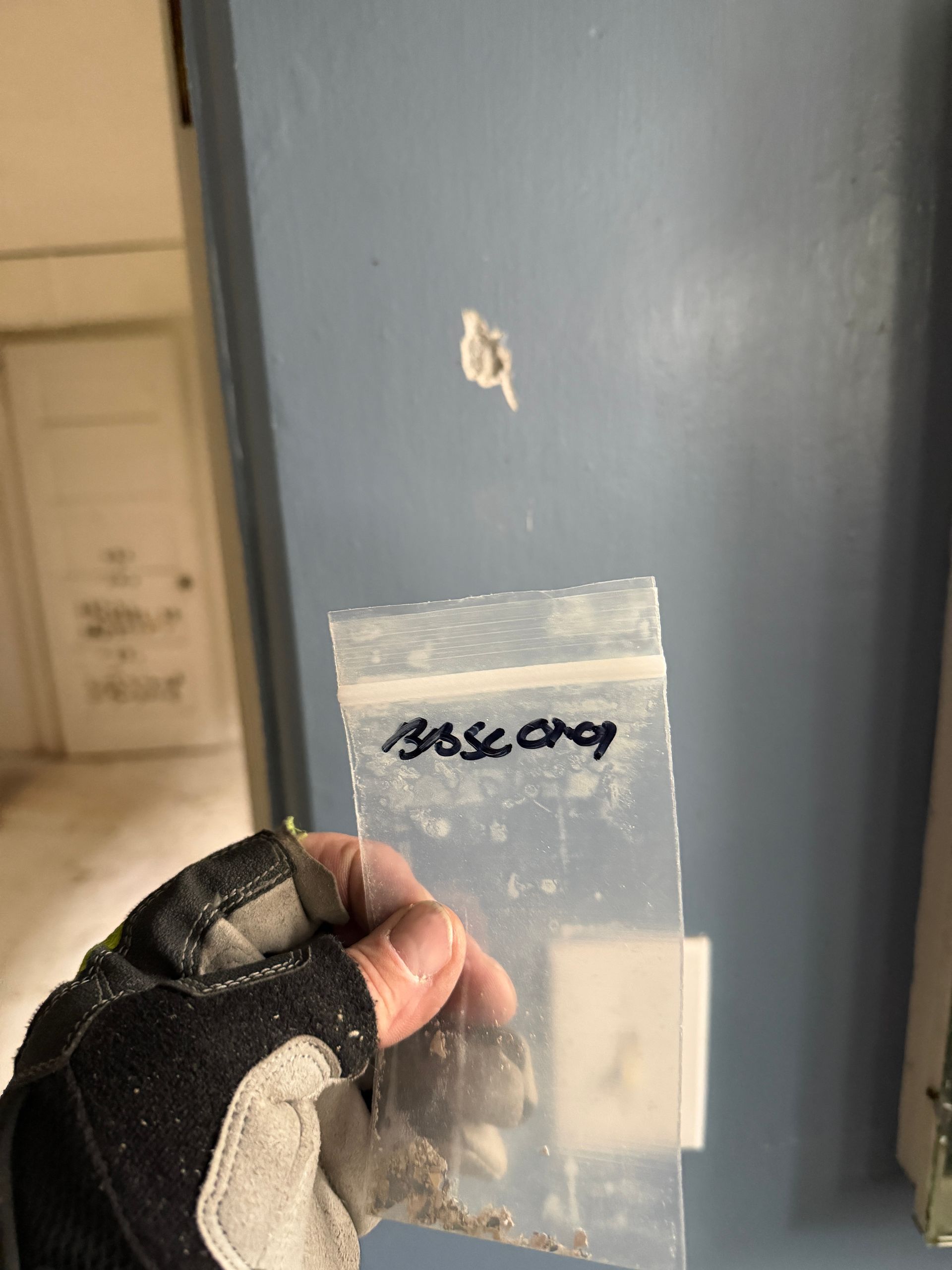 Hand holding evidence bag labeled 