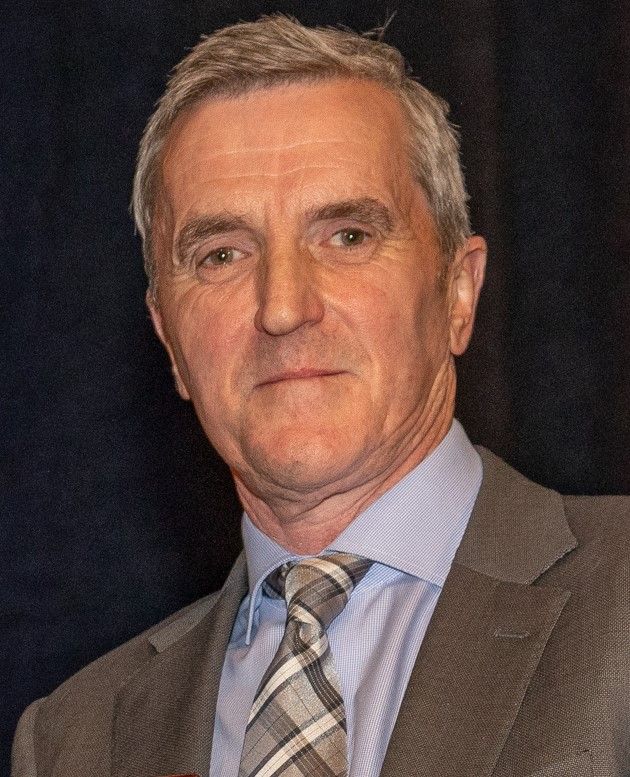 A man in a suit and tie is looking at the camera