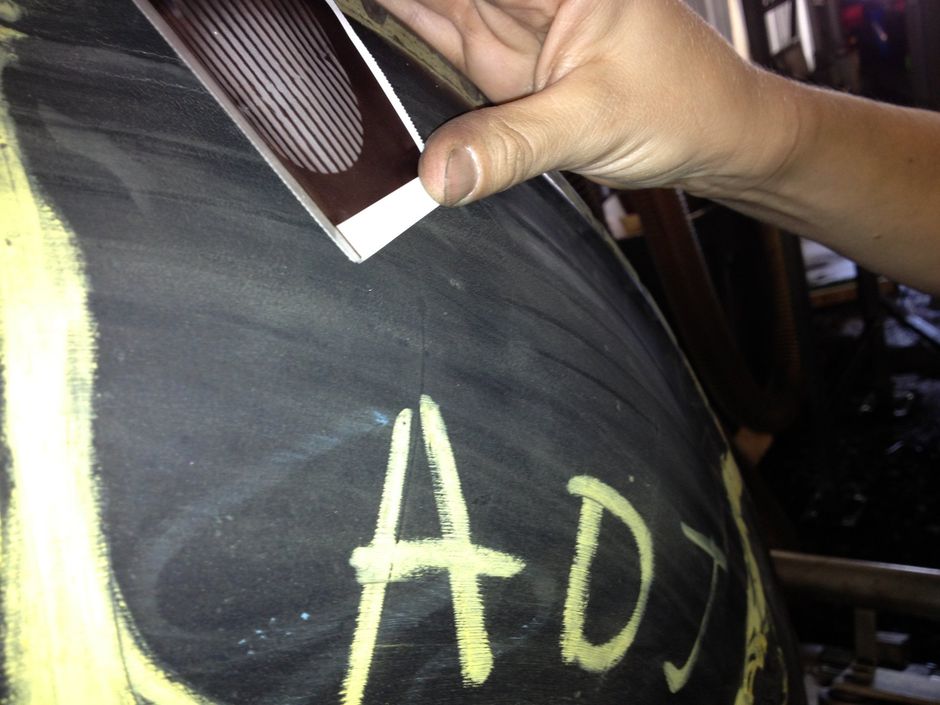 A person is writing the word ad on a chalkboard