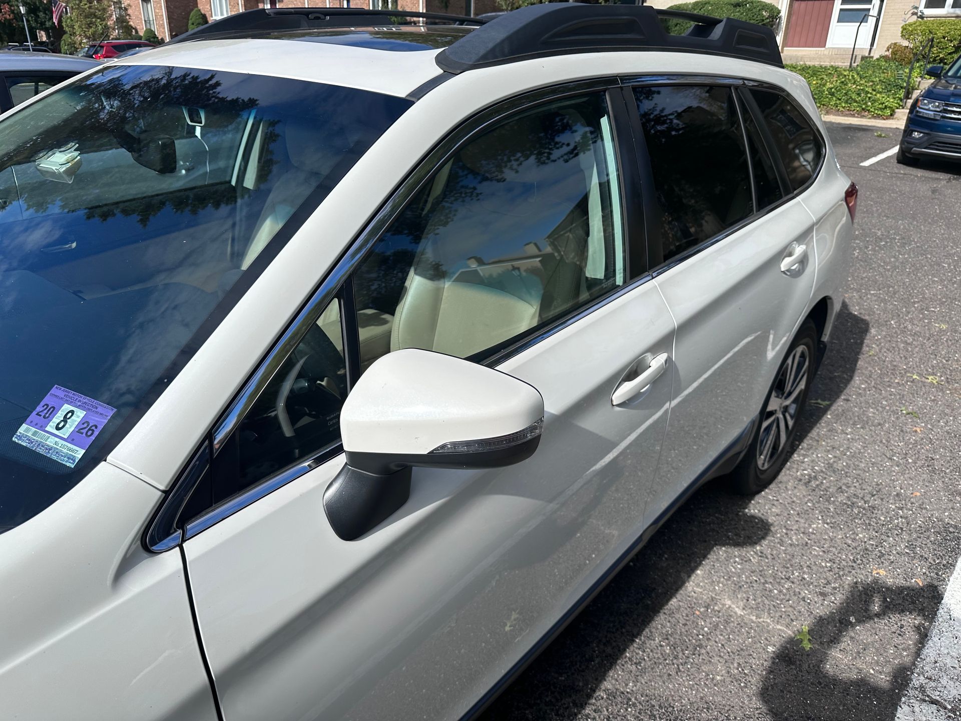 Silver SUV parked on a residential street, front-left side view with beige interior visible