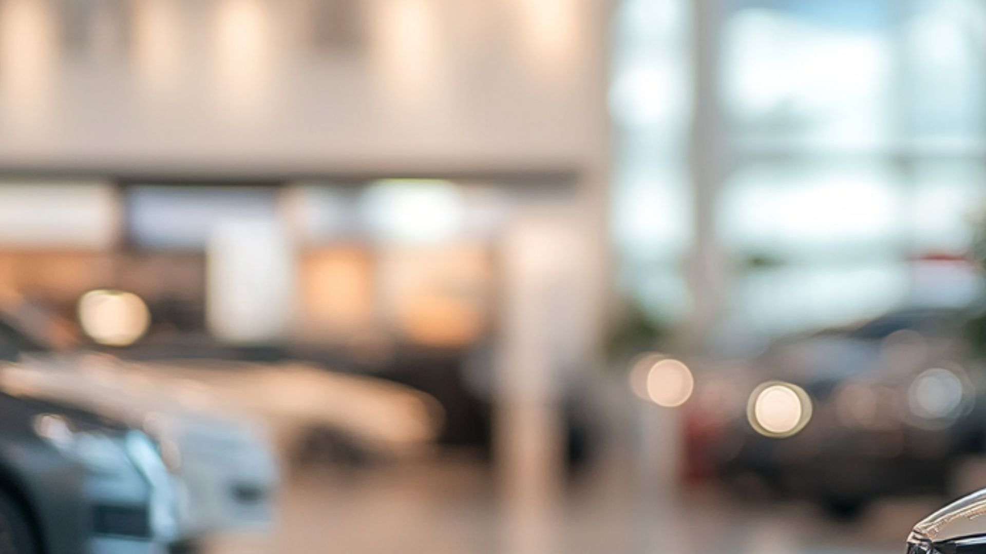 A blurry picture of a car dealership with a car in the background.
