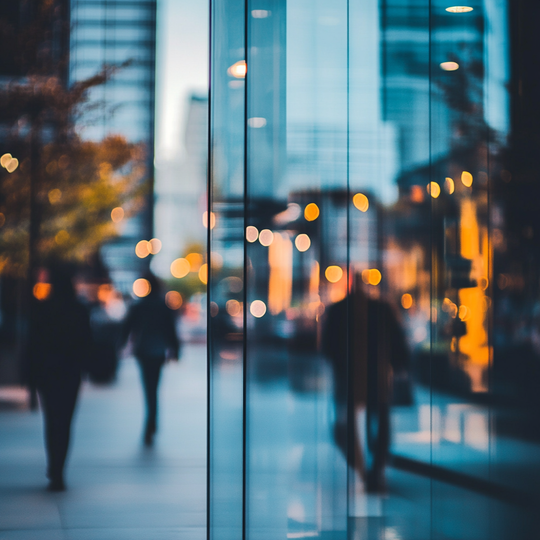 A blurry picture of people walking in front of a glass building.