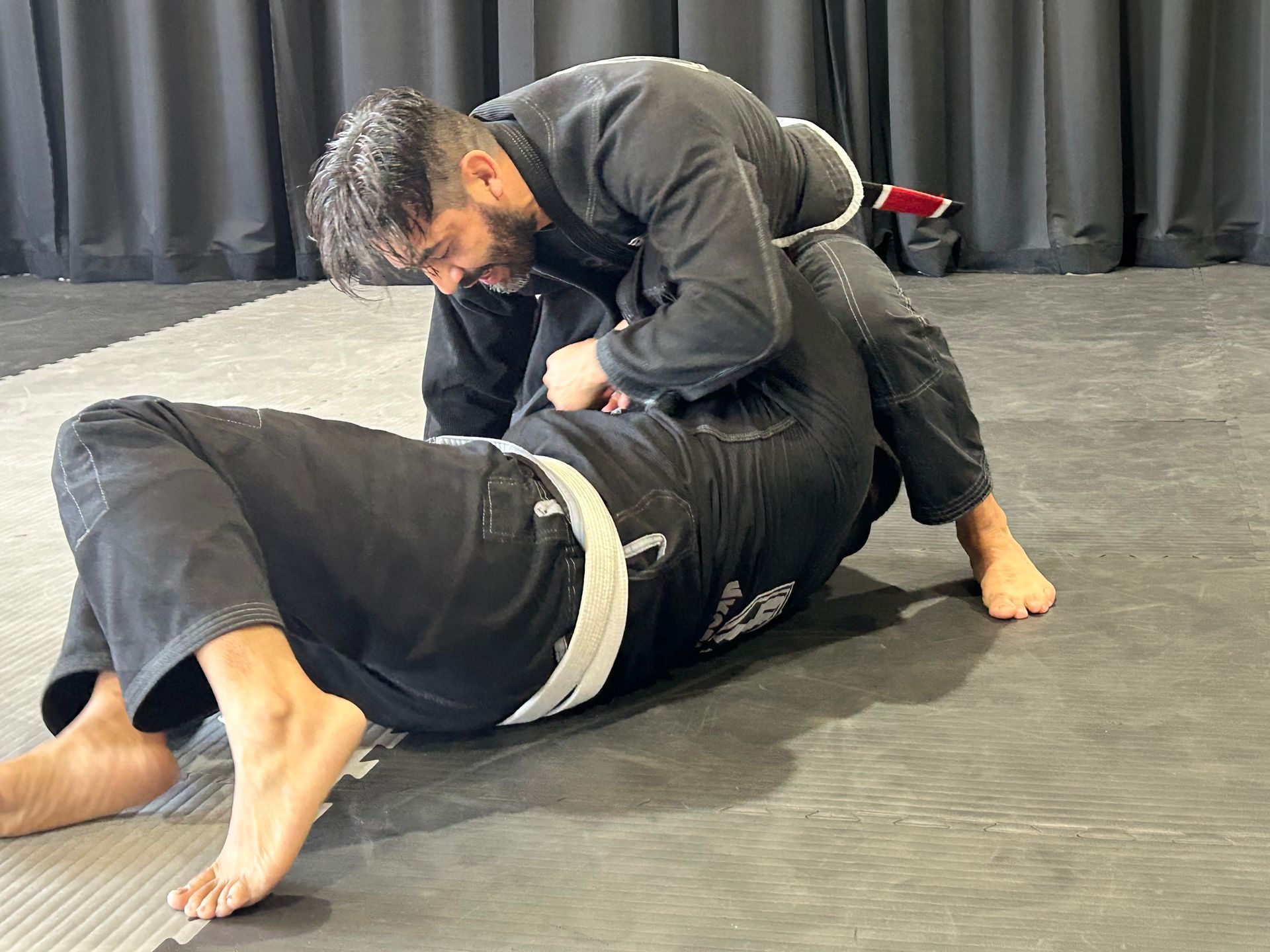 Martial arts class in 4Korners Jiu-Jitsu in Princeton, TX, students in black gis bowing in two lines around a central instructor.