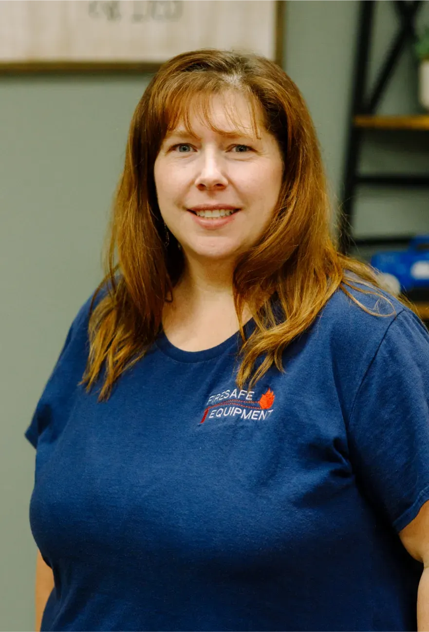 A woman is wearing a blue shirt and smiling for the camera.
