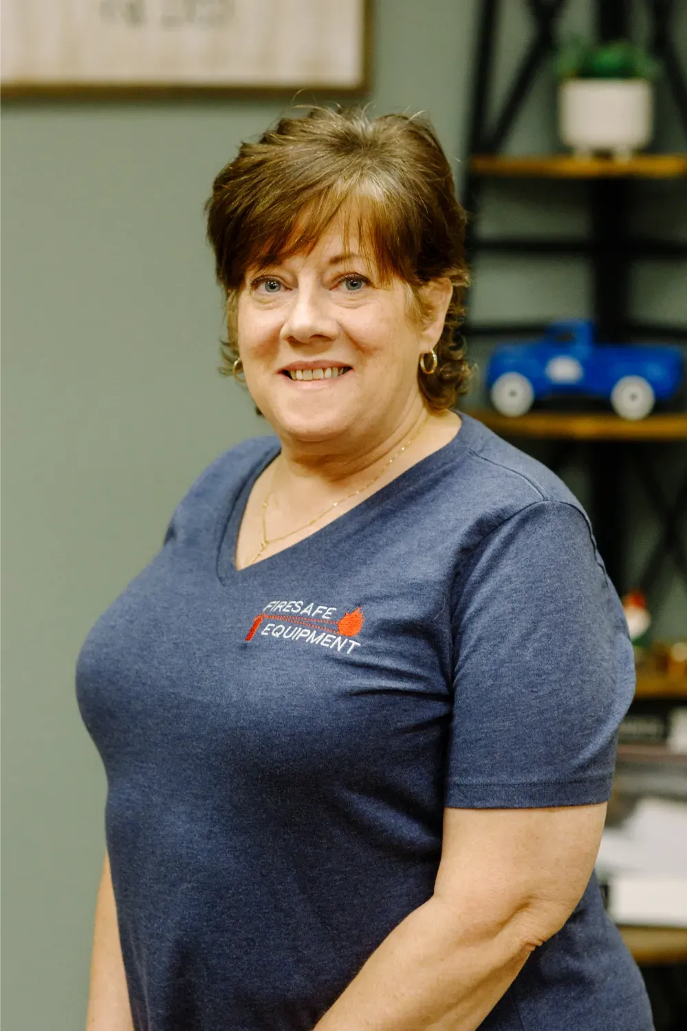 A woman wearing a blue t-shirt is smiling for the camera.